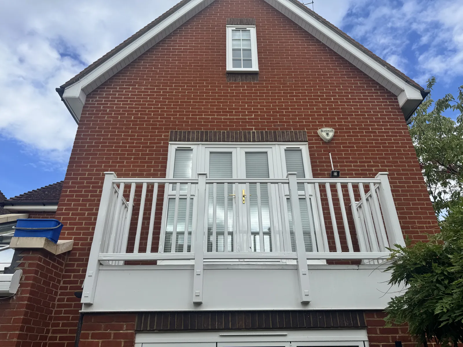 White balcony and cleaned sash windows on a red brick house