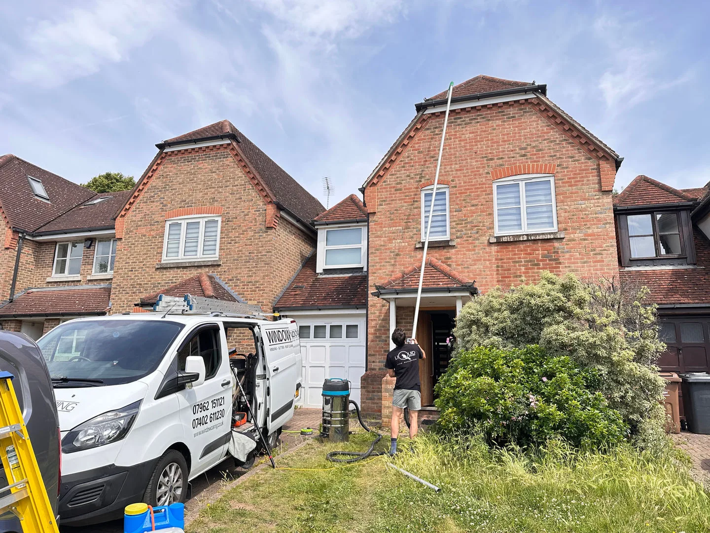 The van parked up and the pole in use at a pair of red brick houses